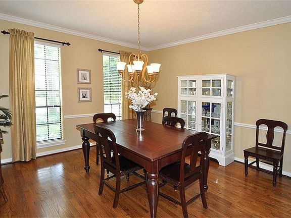 Formal dining with wood floors and crown molding.