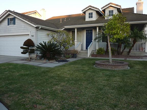 Another view of the front with wrap around porch and green lawn