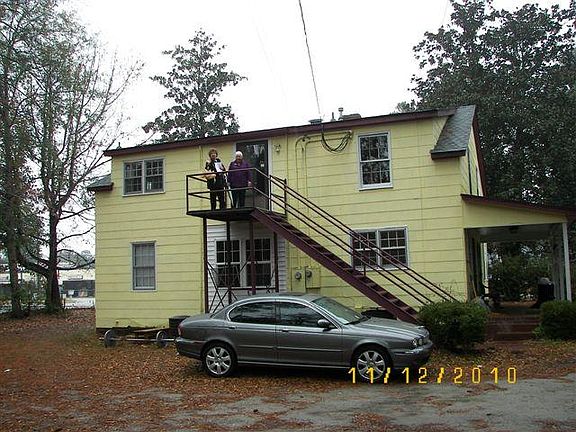 Rear of shows entry to upper unit, and didicated parking.