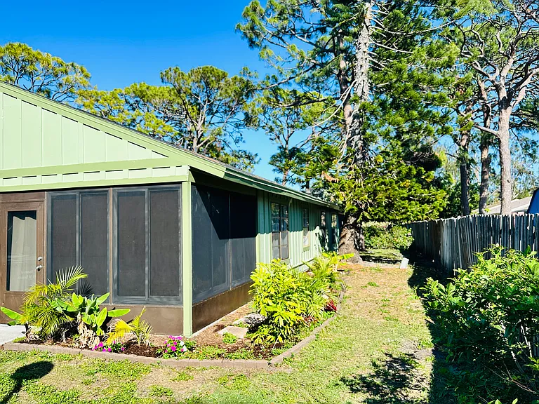 Outside of lanai/Florida room. Totally enclosed with glass and screens. Nice landscaping outside. Fence creating privacy.