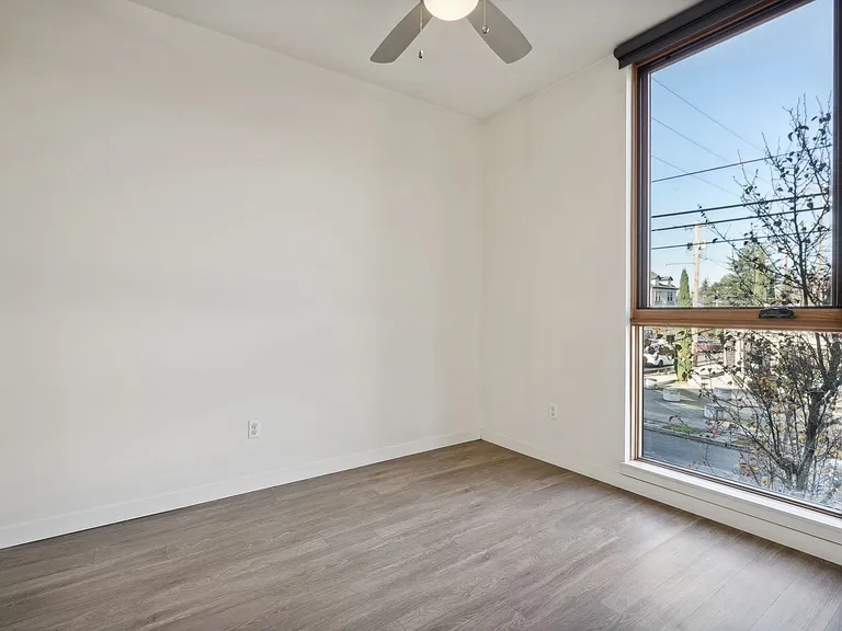 Bedroom with large window and ceiling fan.
