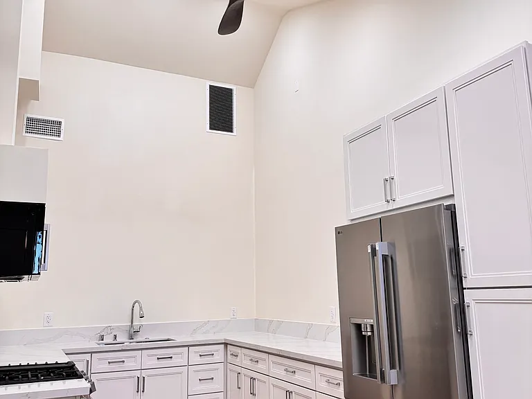 Kitchen with high ceiling, recessed light and a fan