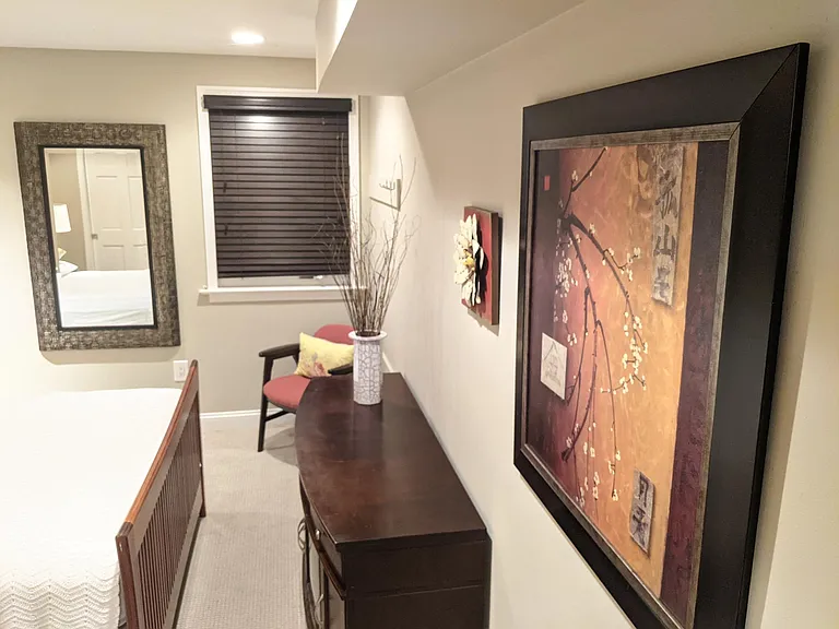 Spacious main bedroom with heavy, high-art mirror.