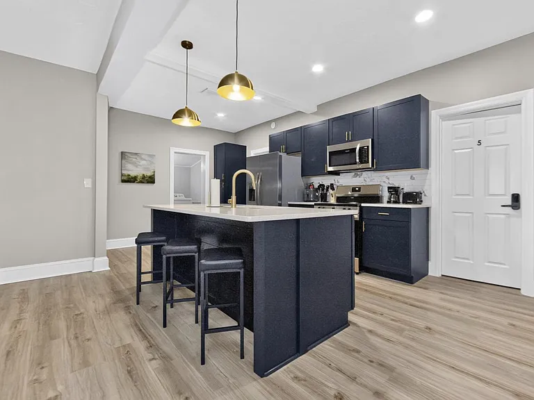 Kitchen with a large island and bar seating, ample cabinet storage, and stainless-steel appliances for daily cooking.