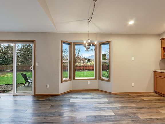 Family room with eating area and open kitchen has lovely view of back yard.