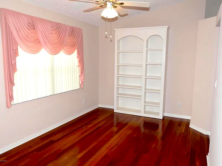 Dining room with ceiling fan and big window facing front of the house.