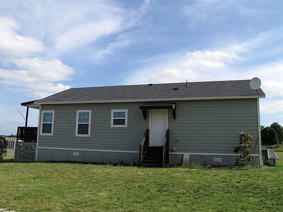 Side view of the larger home with a side door leading towards the smaller home