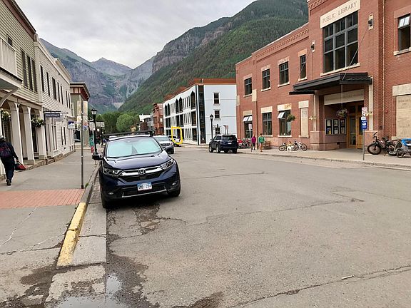 View down Pacific Avenue toward Bridal Veil Falls. The library is on the right. The front/deck of Fall Line #103 is circled in yellow down the block.