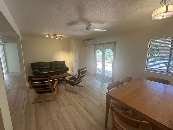 Living room with table and 6 chairs, coffee table, 2 ikea poang chairs and leather coach. Kitchen island. New ceiling fan and paint and new luxury vinyl flooring throughout unit.