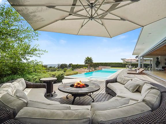 Private patio with a cozy fireplace lounge and stunning views.