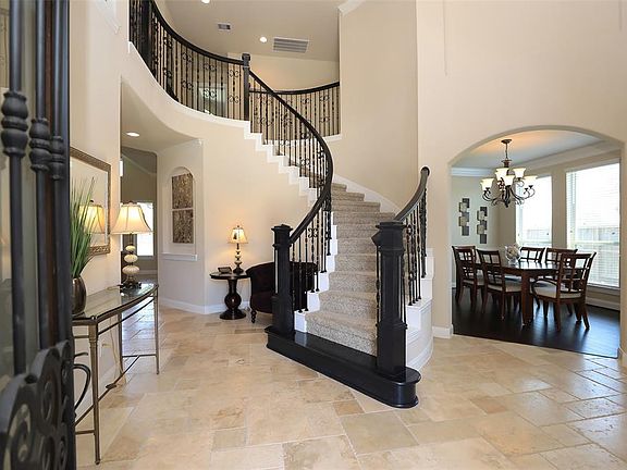Elegant 2 story entry with dramatic curved staircase