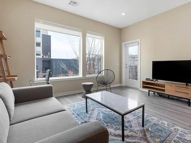 Furnished+ apartment homes come outfitted with a sofa, side chair, side table, coffee table, office chair, desk, TV stand and 50" Television (Representative Image exact items and style of furnishings may vary)