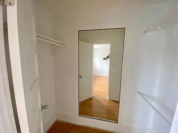 Freshly painted walk-in closet with a full-length mirror.