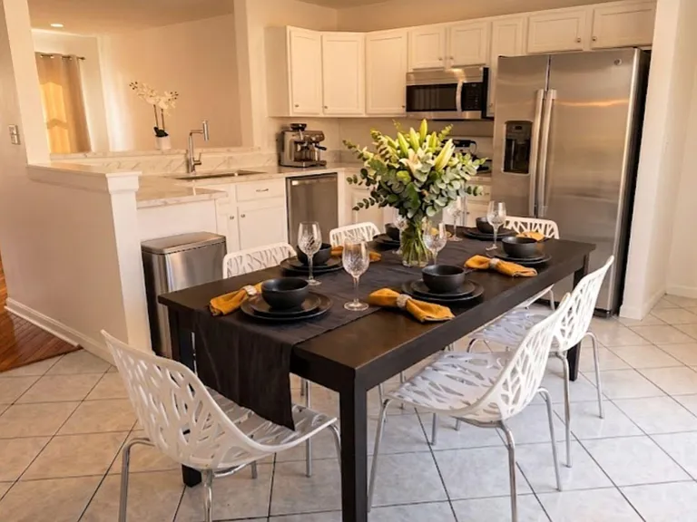 Open-concept eat-in kitchen with ample cabinetry, stainless appliances, and a full dining table for shared meals.