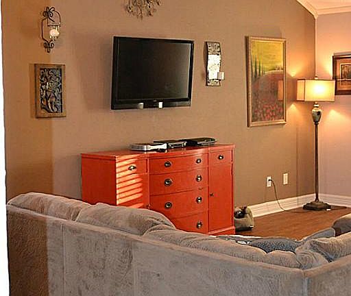 Large living room with soaring ceilings. Features large windows, crown molding and new flooring