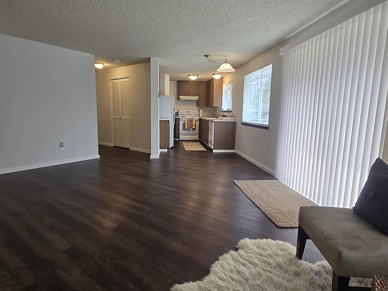 View toward hall entry, coat closet, dining area and galley kitchen. (rugs and staging items not included).