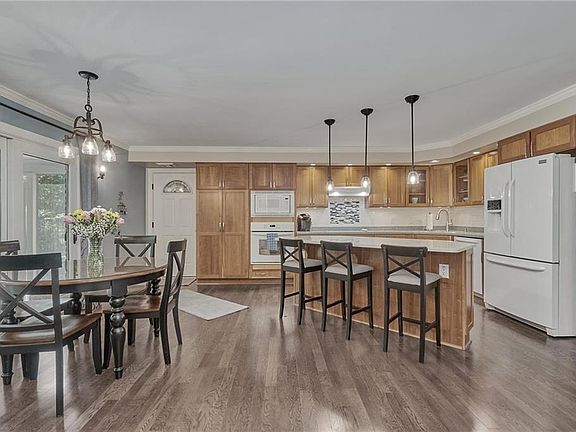 Remodeled Kitchen and Dining feature a Generous Island with Quartz Countertop, Cherry Cabinetry and access to the Screened Porch for Outdoor Living