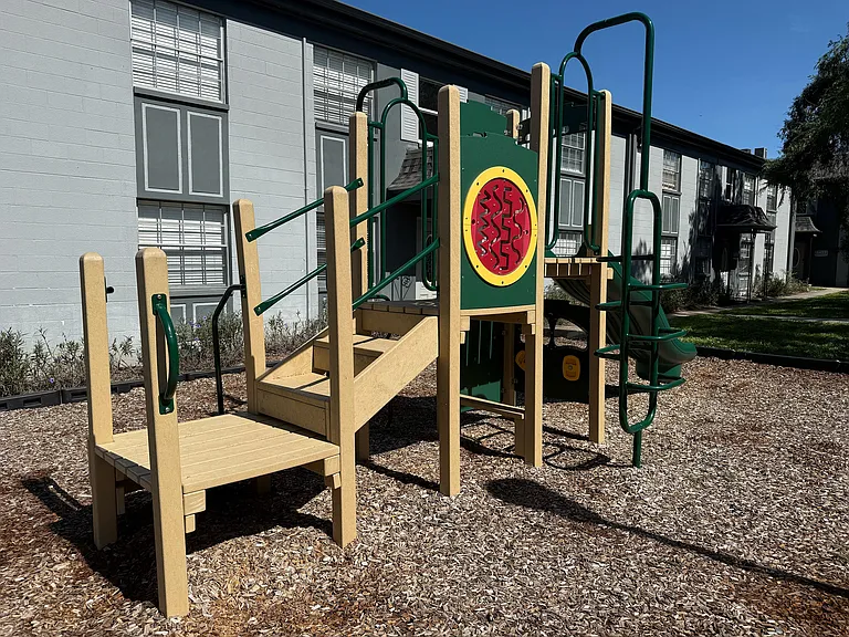 Inviting outdoor playground with a colorful climbing structure, perfect for family fun in a well-maintained residential community.