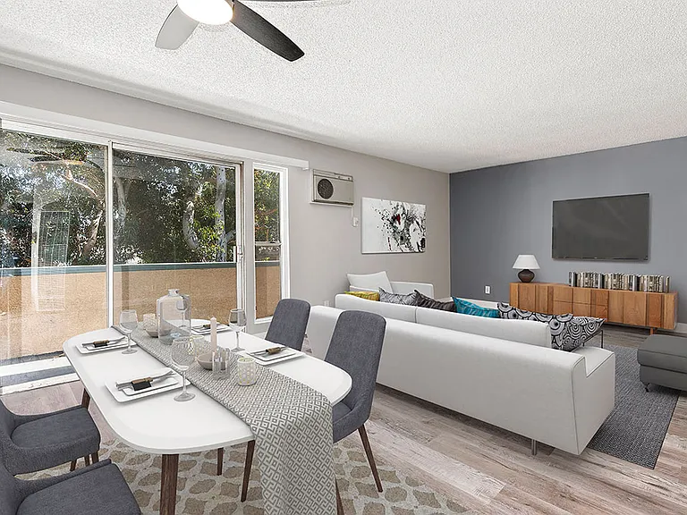 Hardwood floored dining room with ceiling fan and view of living room and private balcony.
