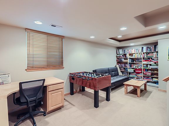 Lower level private family room with built in desk, foosball table, futon, TV and built-in book/game shelves.