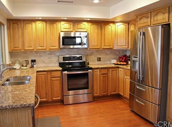 Updated kitchen with stainless steel appliances, travertine backsplash and granite counters.
