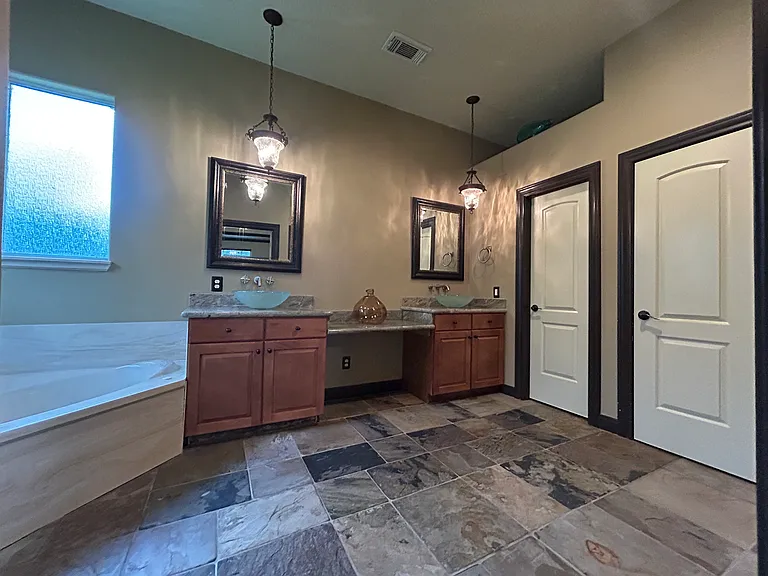 master bath with beautiful glass bowl sinks, jacuzzi tub, and huge walk-in closet