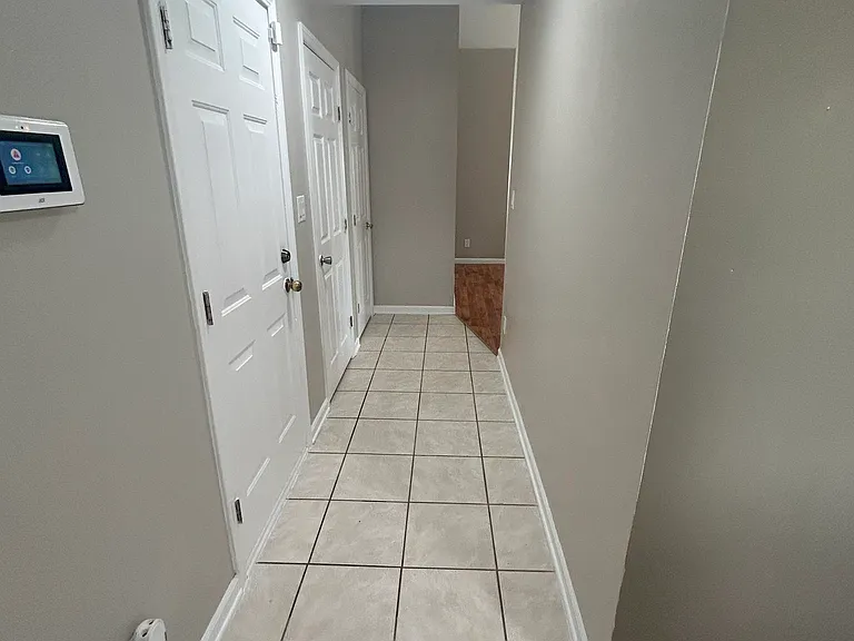 Hallway leading to the livingroom with the entry doors on the left to garage and loft
