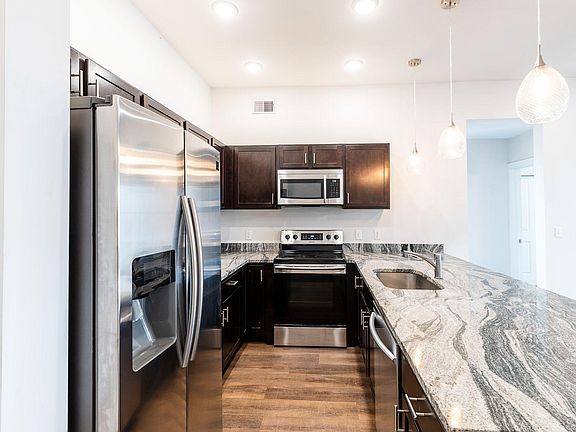 Spacious kitchen with wood cabinets, granite counters and stainless appliances.