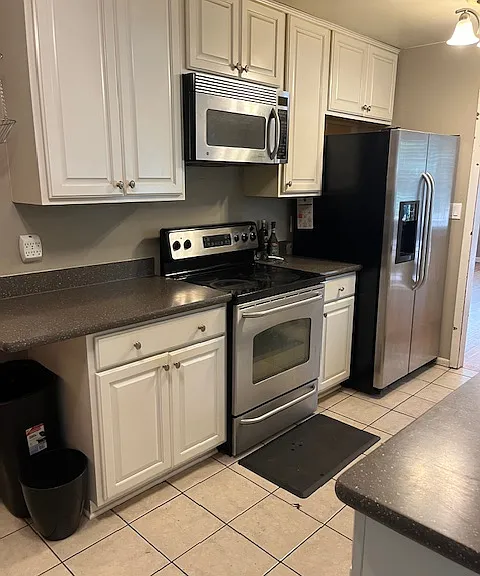 Nice kitchen with stainless steel appliance. Microwave hood over electric stove.