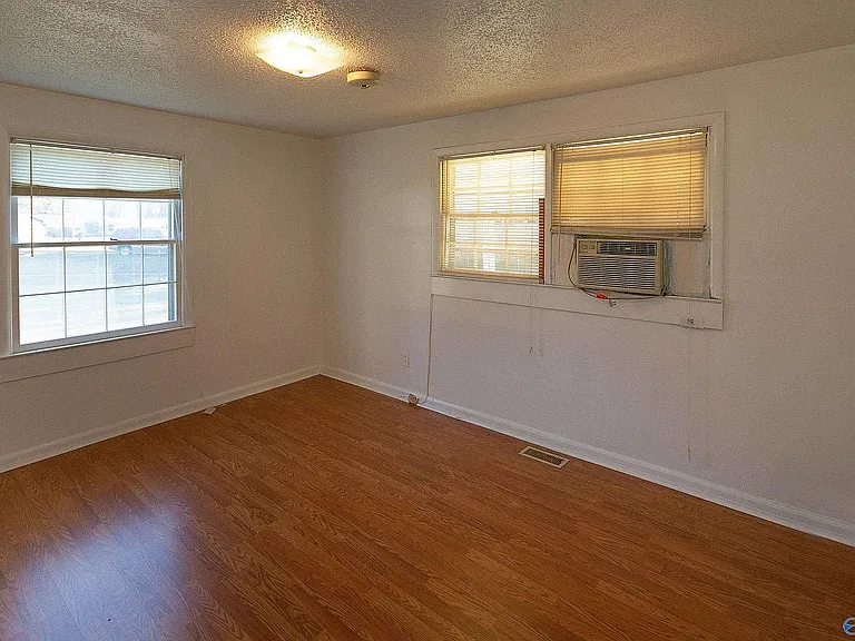 View of the master bedroom showing the side window (closet is to the left) & the back window(s). The window AC is gone now. The door into the room is to the left & behind the photographer.