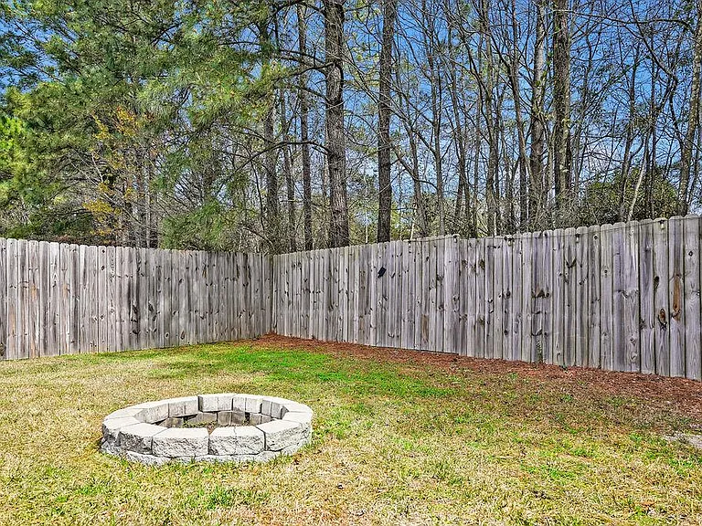 Privacy fenced in backyard with fire pit.