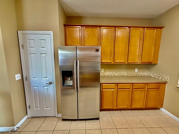 Spacious stainless steel fridge with ample cabinets for storage.