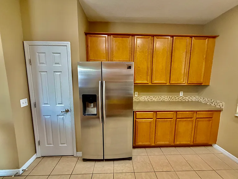 Spacious stainless steel fridge with ample cabinets for storage.
