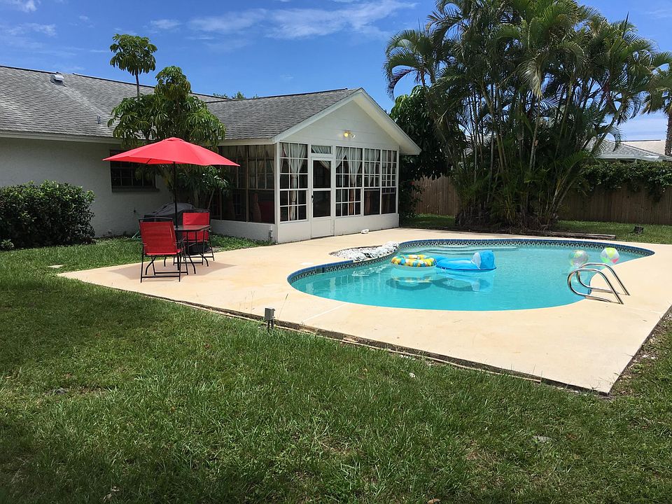 Large exterior patio with grilling area next to the pool.