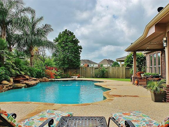 Your new back yard oasis awaits you at 2110 Quiet Falls Ln. A diving board, rock waterfall, huge extended covered patio and lush professional landscaping makes this salt water pool feel like you're at a resort.