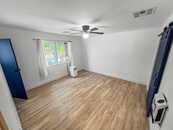 Master bedroom with on-suite bathroom, walk-in closet, sliding barn door, and a/c unit.
