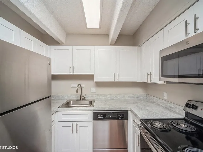 Sleek, updated kitchen with white cabinetry and stainless steel appliances