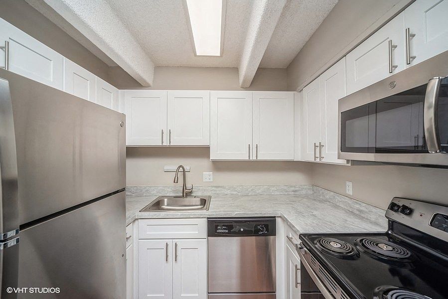 Sleek, updated kitchen with white cabinetry and stainless steel appliances