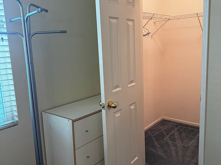 Bedroom #1: coat hanger, chest of drawers, walk-in-closet with light and wrap-around shelf