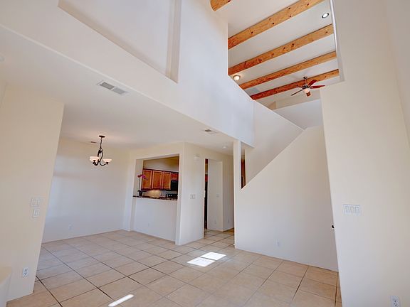 View of living and dining rooms on lower level - note the vaulted ceilings with wood vigas