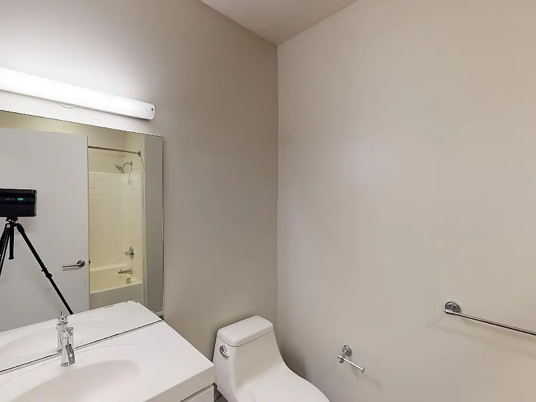 Apartment bathroom with polished concrete flooring.