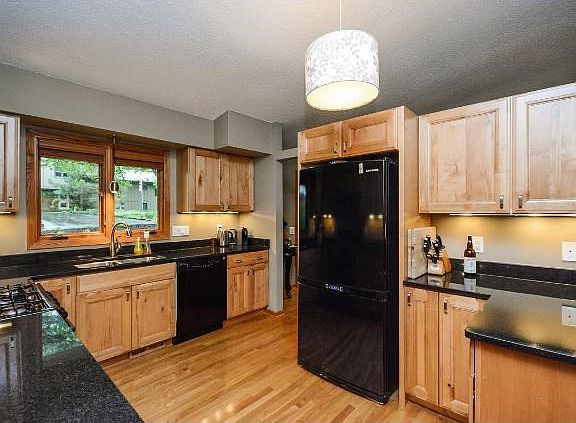 Well designed kitchen with granite counters, hardwood floors and convenient access to garage for groceries.