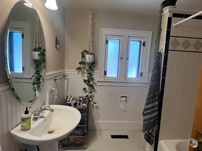 April 2026-Bathroom, funtional windows with screens, original penny tile flooring, pedestal sink, updated wall tile, original doors, full length mirror, beadboard walls
