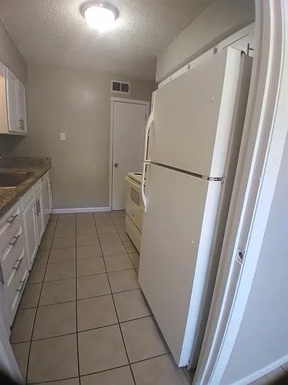 Refrigerator, stove, and dishwasher included with lots of cabinety and a panty closet.