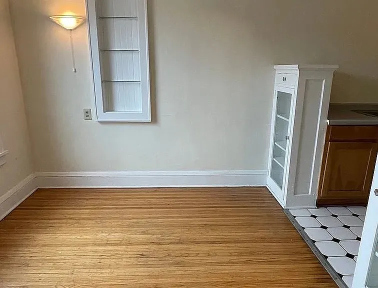Step into the charm of LS Capital Group, where spacious living meets vintage elegance. This inviting room features beautiful hardwood floors and ample natural light, perfect for your personal touch. Make it yours today!