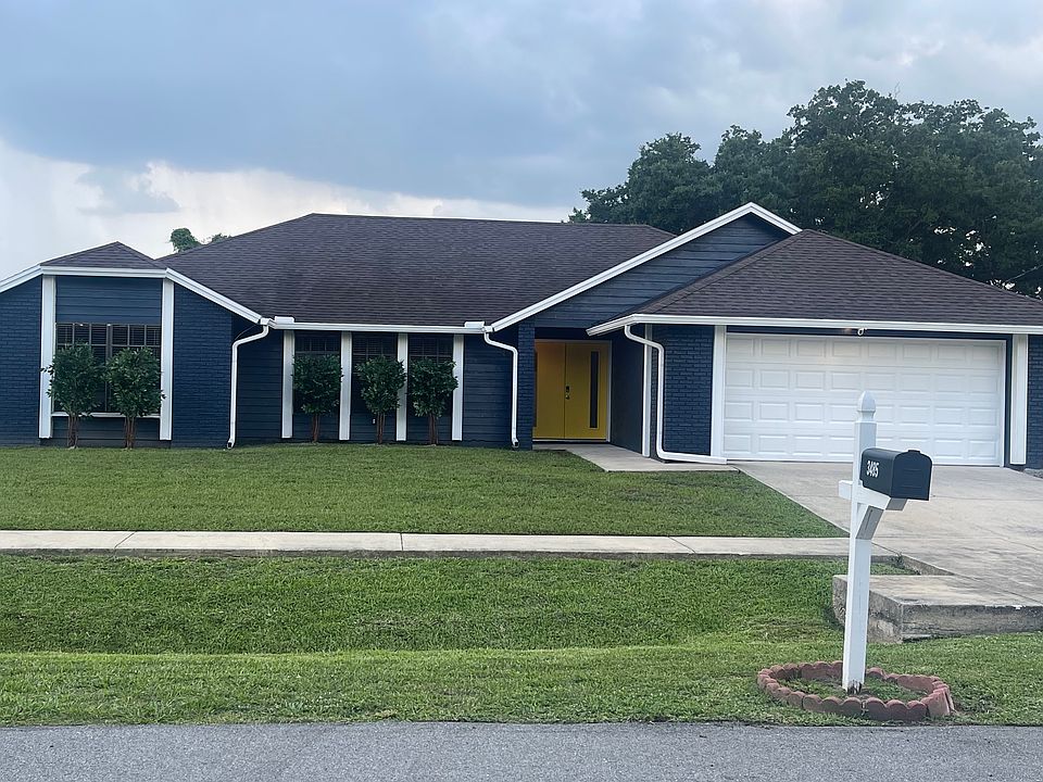 Front facade. Painted 2023 navy and white with yellow double door.