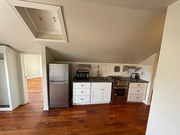Kitchen with range, fridge, microwave and Nespresso coffee maker.