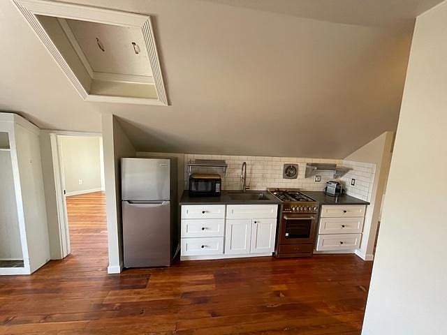 Kitchen with range, fridge, microwave and Nespresso coffee maker.