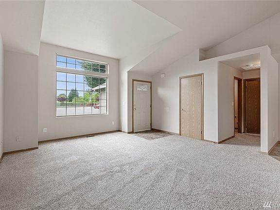 The entry opens into a luminous vaulted living room. 