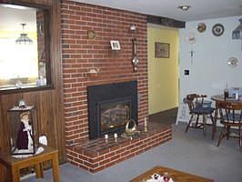 Living room with gas fireplace and hardwood under carpet